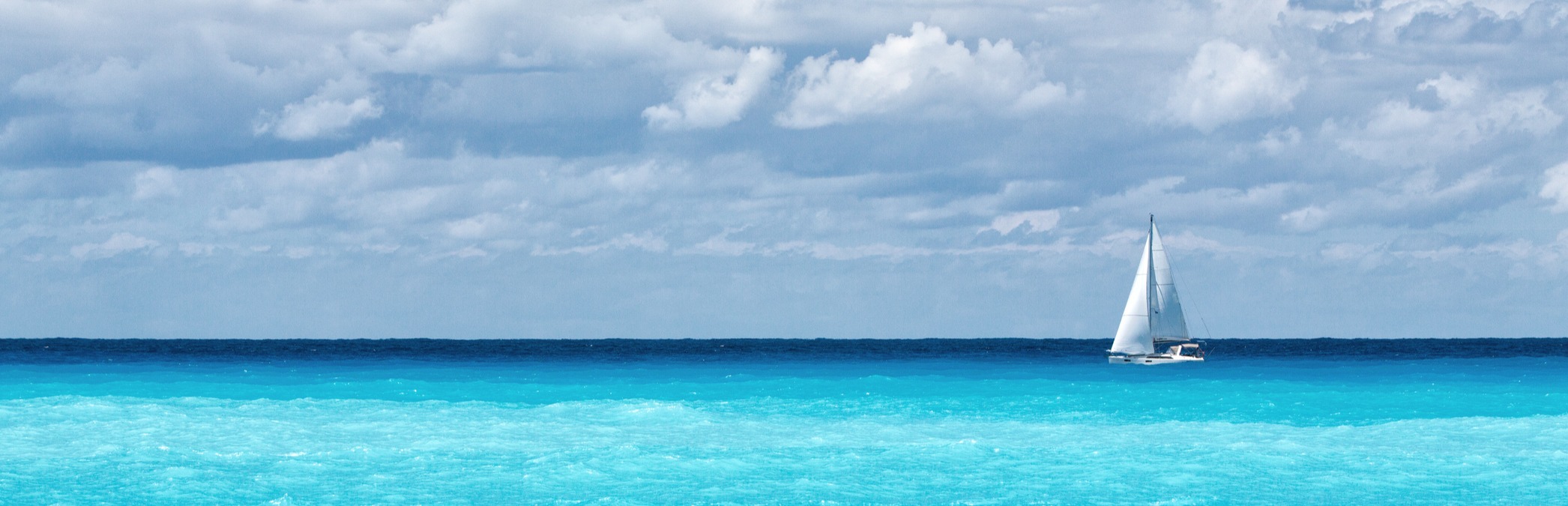 Sailboat crossing bright blue water, imagery featured by Keim Financial Group